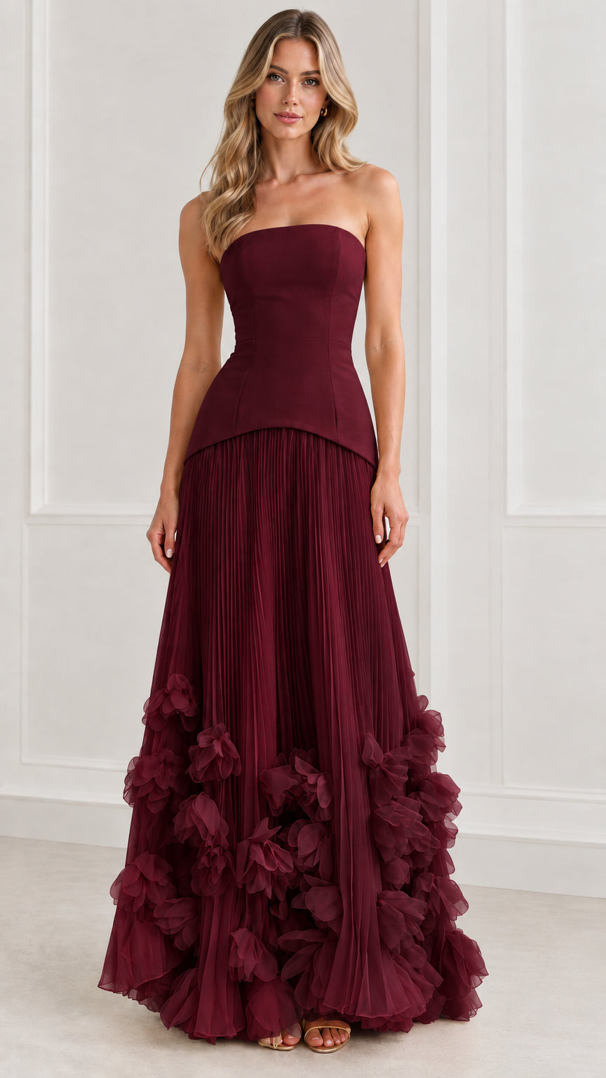 Front view of model wearing rich burgundy strapless corset pleated evening gown