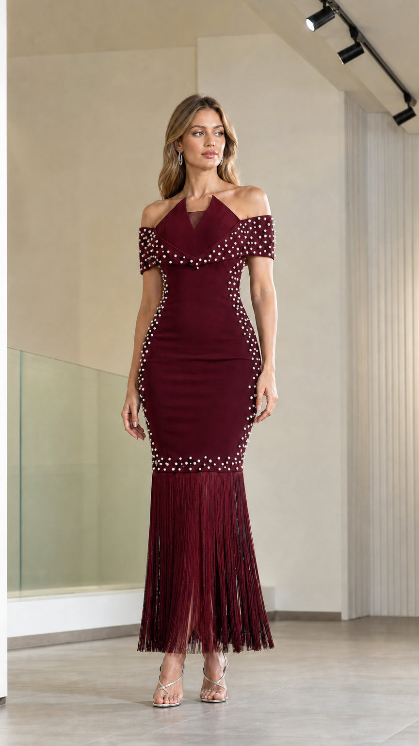 Model wearing burgundy red off-the-shoulder pearl embellished fringe evening dress