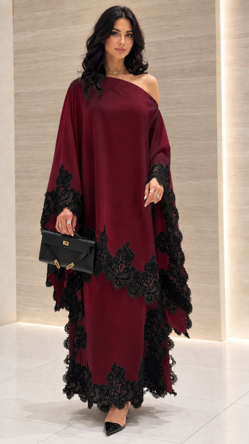 Front view of burgundy wine red one-shoulder draped maxi dress with black lace trim