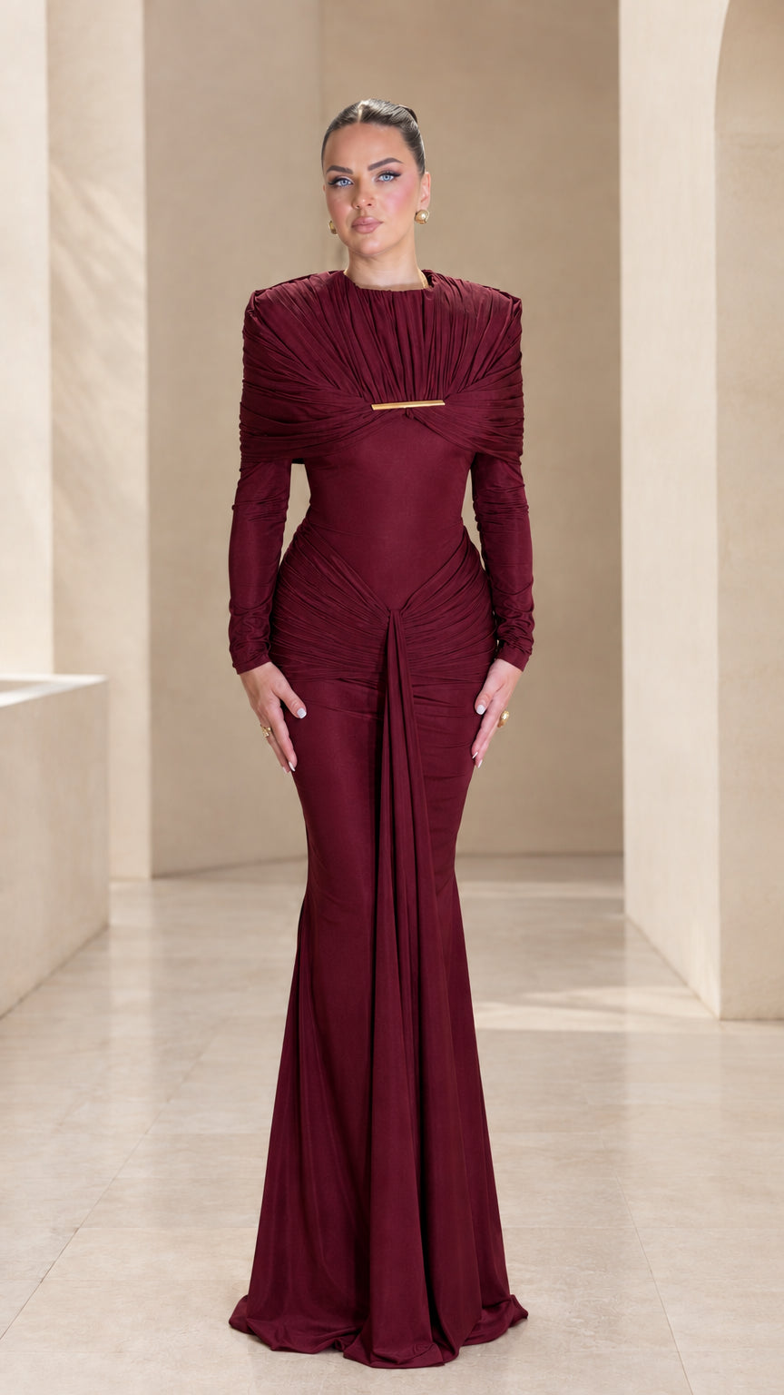 Front view of burgundy wine red long sleeve pleated cape evening gown