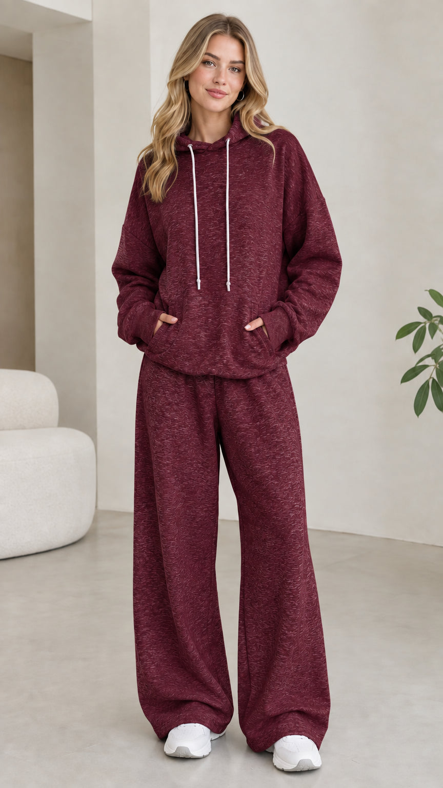 Model wearing burgundy red 2-piece drawstring hoodie and wide leg sweatpants set