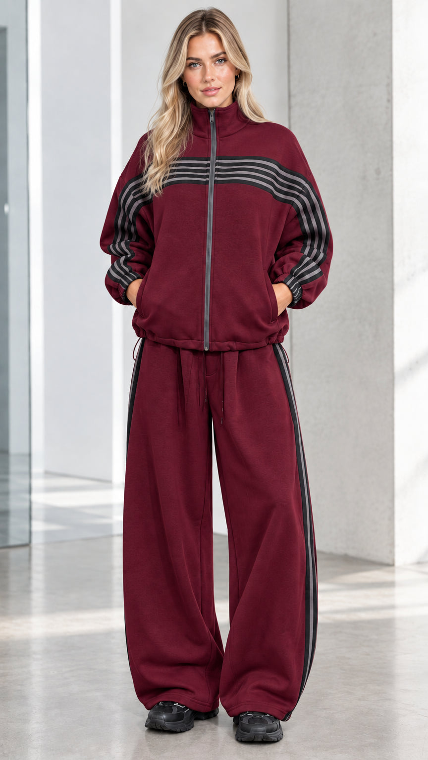Front full view of woman wearing Burgundy striped zip-up track jacket and wide-leg sweatpants set