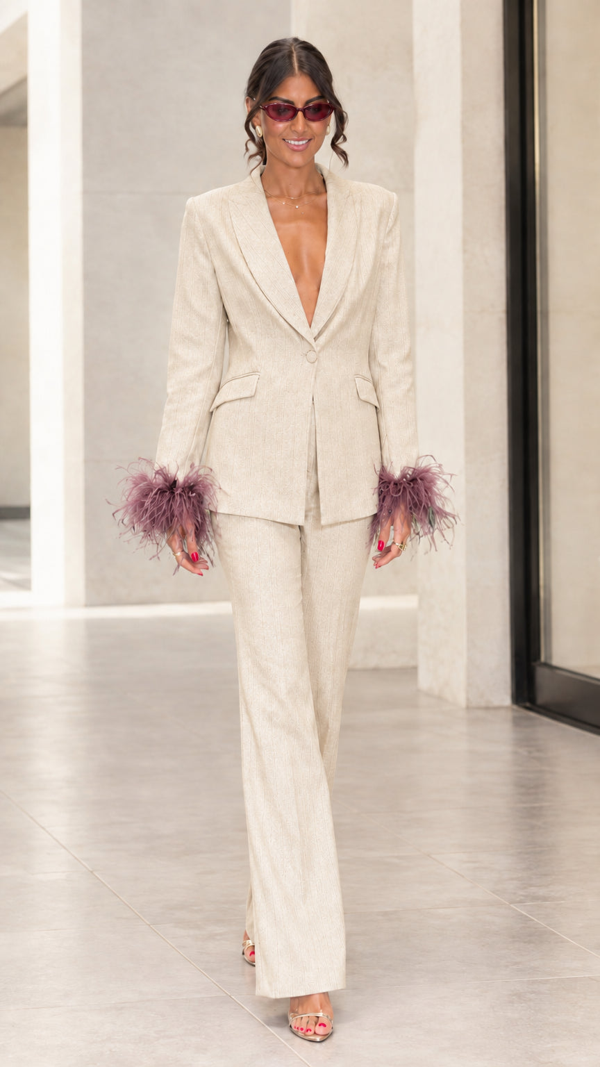 Front view of woman wearing champagne cream tailored suit set with mauve feather cuffs