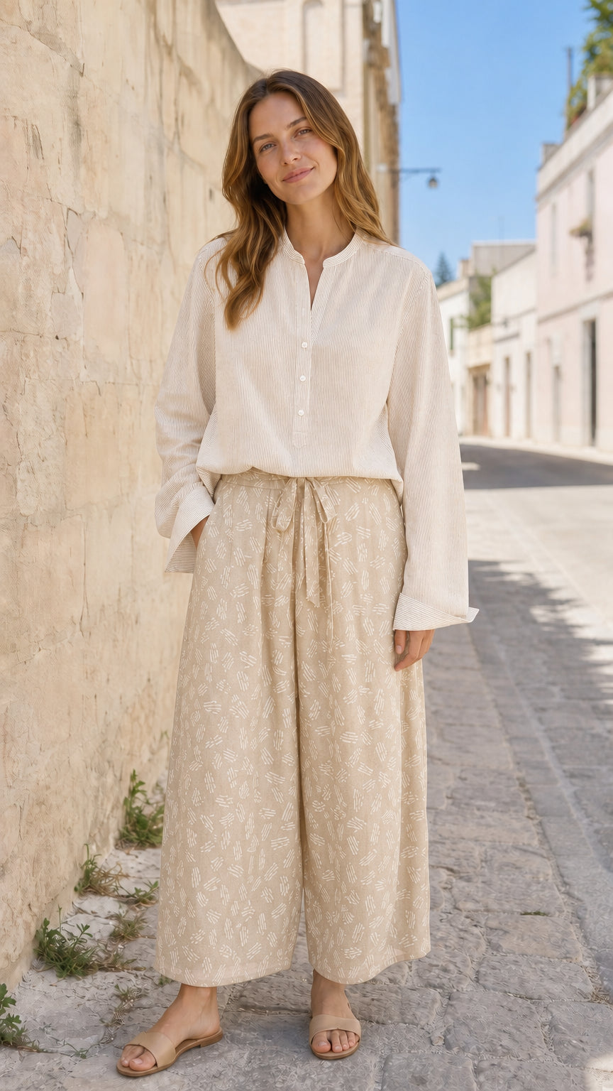 Woman wearing beige two-piece blouse and printed pants set