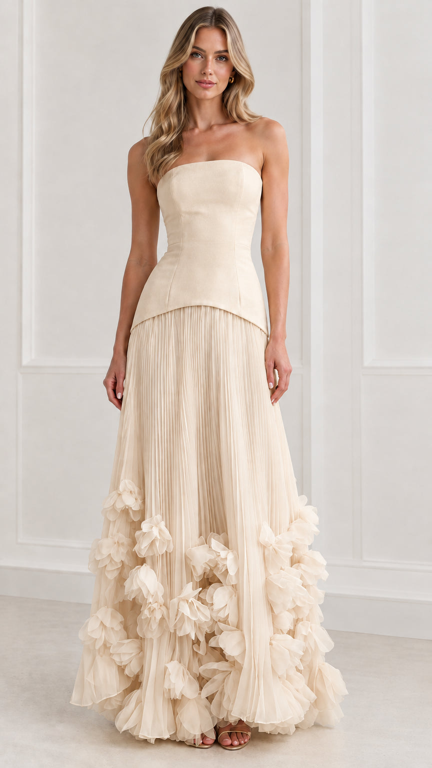 Front view of model wearing champagne cream strapless pleated maxi dress with 3D florals