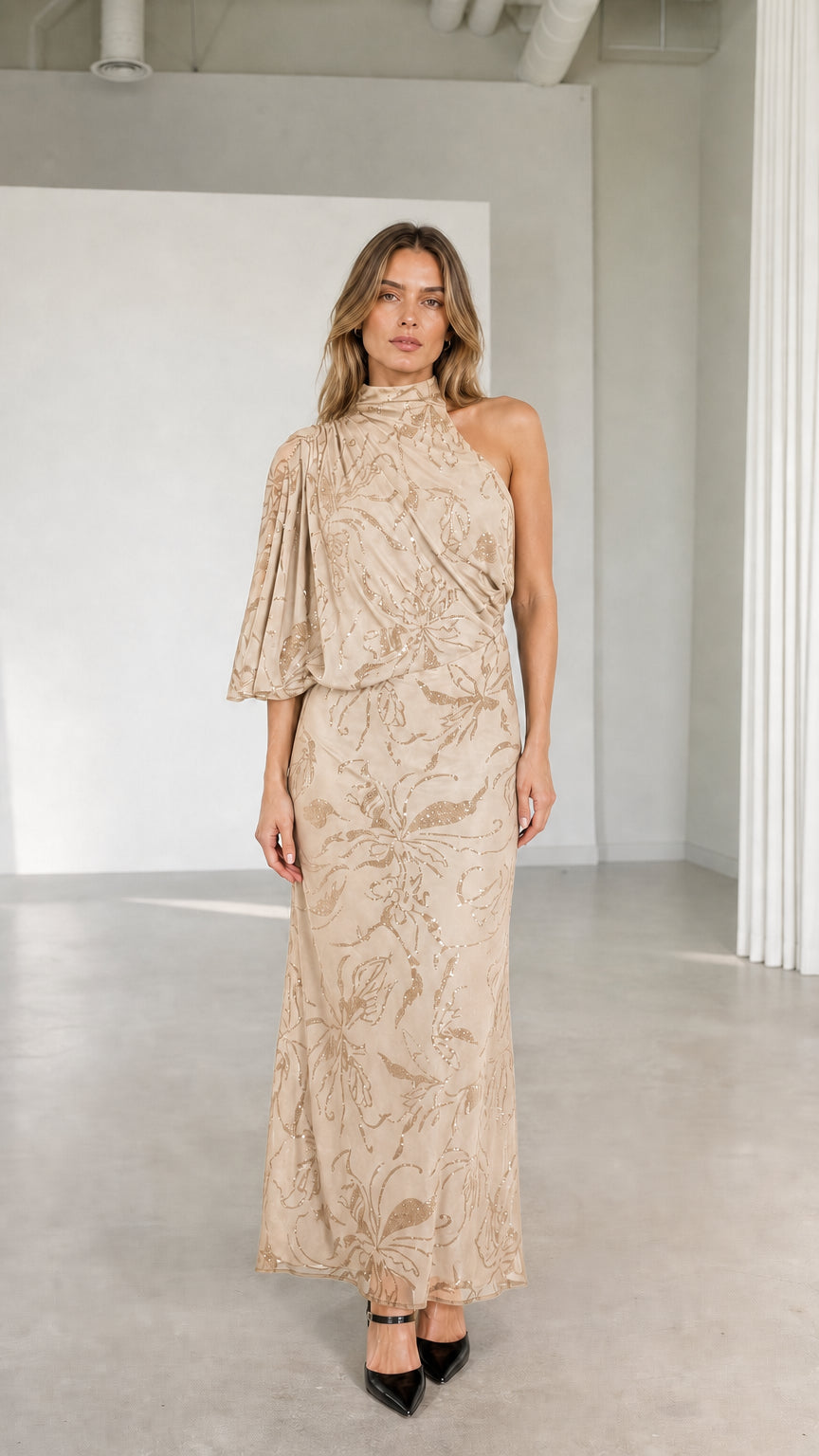 Model wearing champagne beige one-shoulder high neck embellished maxi dress