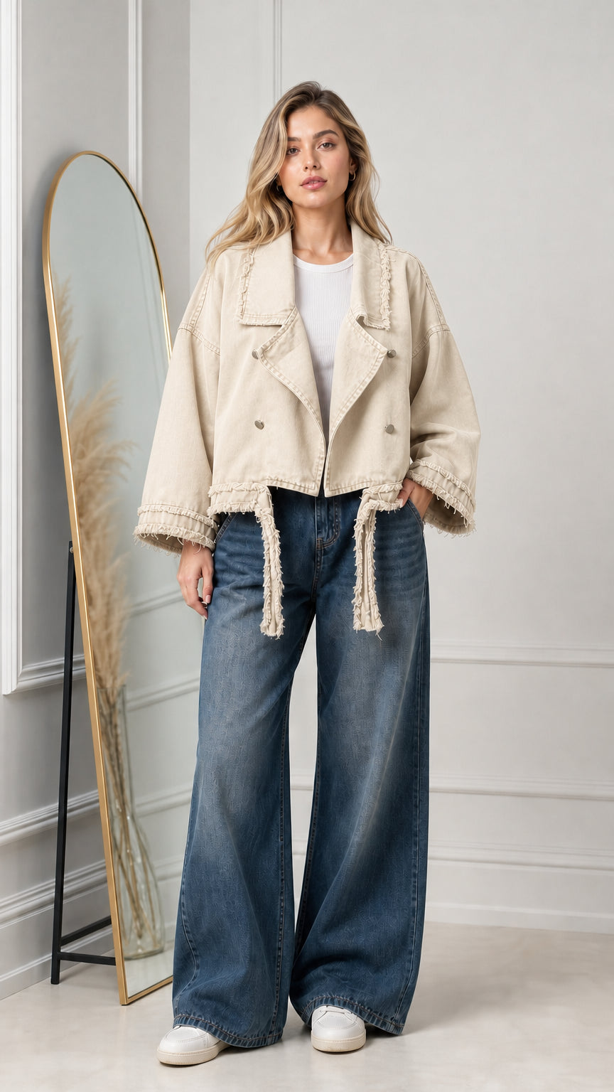 Model wearing beige cropped denim moto jacket with frayed accents